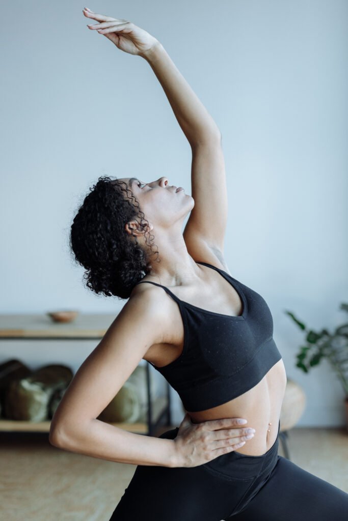 Selective focus photo of a woman in black activewear doing a yoga pose